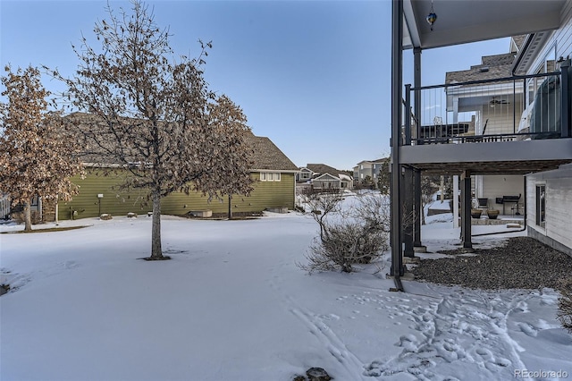 yard covered in snow featuring a balcony