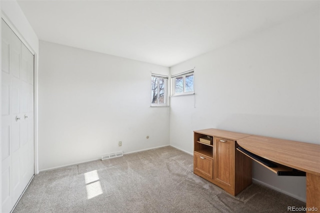 unfurnished office featuring light colored carpet and visible vents