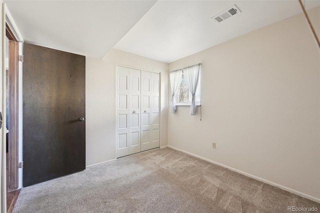 unfurnished bedroom with a closet, baseboards, visible vents, and carpet floors