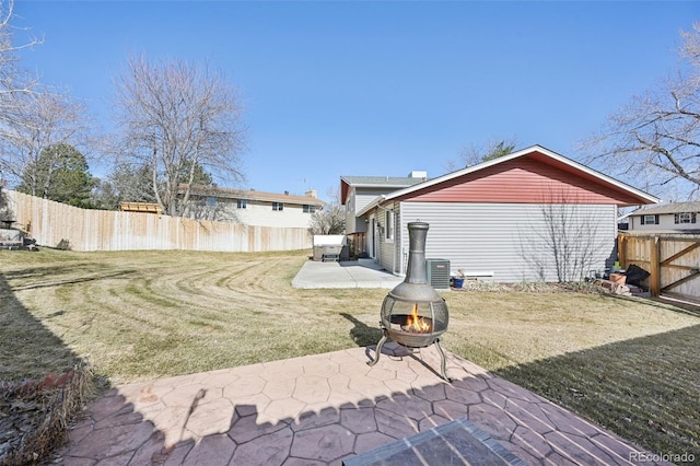 view of yard featuring a patio, a fire pit, central AC unit, and a fenced backyard