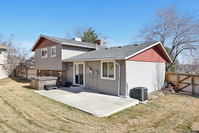 back of house featuring a hot tub, central AC unit, a yard, a fenced backyard, and a patio