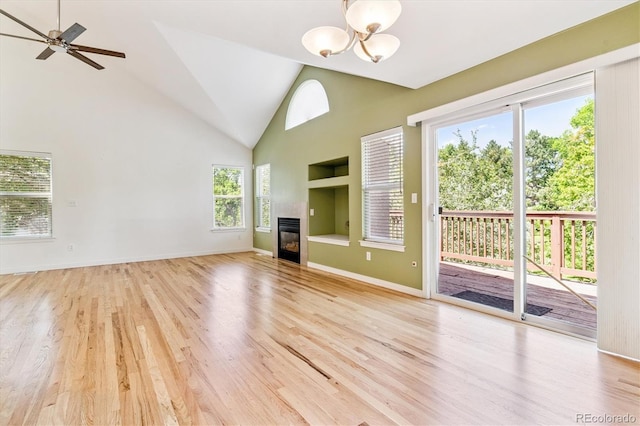 2330 S Salem Cir, Aurora, CO 80014 - unfurnished living room with a chandelier, a tiled fireplace, healthy amount of natural light, light wood-style floors, and high vaulted ceiling