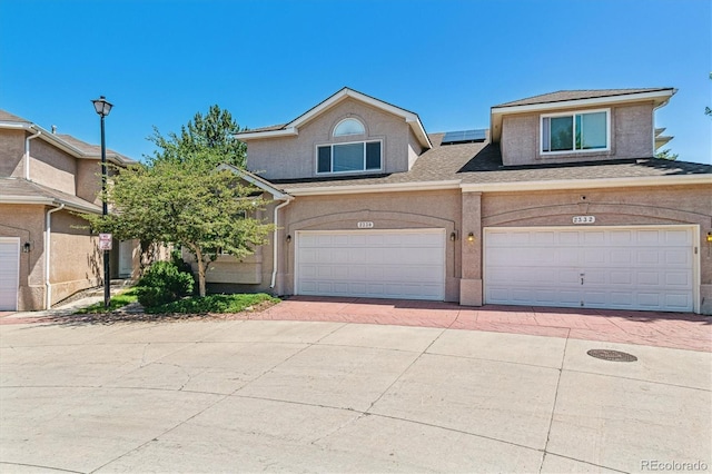2330 S Salem Cir, Aurora, CO 80014 - view of front facade with solar panels, decorative driveway, a garage, stucco siding, and roof with shingles