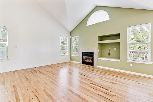 2330 S Salem Cir, Aurora, CO 80014 - unfurnished living room featuring built in features, healthy amount of natural light, high vaulted ceiling, wood finished floors, and a fireplace