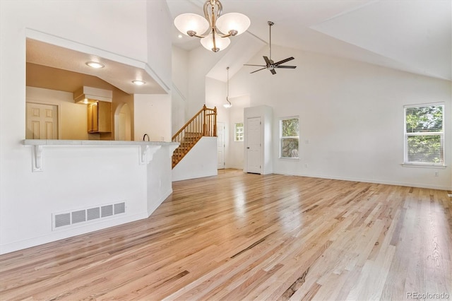 2330 S Salem Cir, Aurora, CO 80014 - unfurnished living room with healthy amount of natural light, a ceiling fan, high vaulted ceiling, a chandelier, and light wood-type flooring