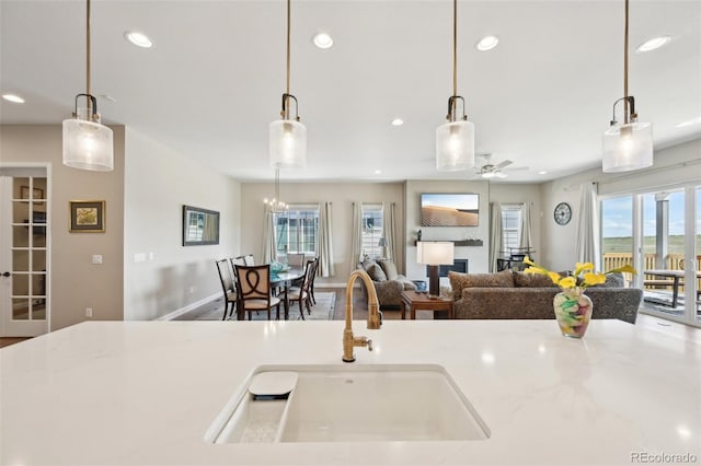6980 S Yantley Ct, Aurora, CO 80016 - kitchen with a sink, recessed lighting, a ceiling fan, open floor plan, and hanging light fixtures