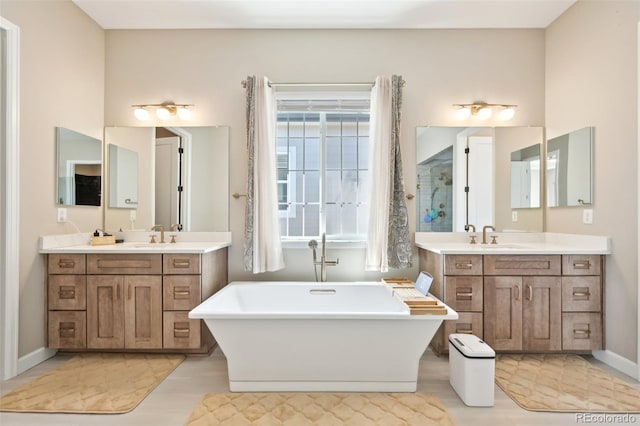 6980 S Yantley Ct, Aurora, CO 80016 - full bath featuring a freestanding bath, two vanities, a walk in shower, and wood finished floors