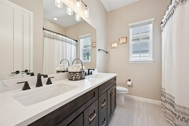 6980 S Yantley Ct, Aurora, CO 80016 - bathroom with baseboards, toilet, and double vanity