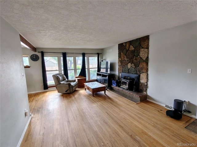 7409 Pierce St, Arvada, CO 80003 - living area featuring a textured ceiling, wood finished floors, and a wood stove