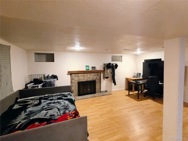 7409 Pierce St, Arvada, CO 80003 - bedroom featuring light wood finished floors, a tile fireplace, and a desk