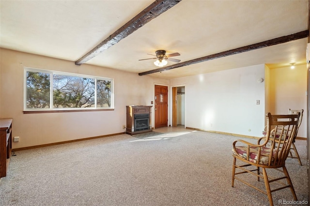 living area featuring beamed ceiling, ceiling fan, and light colored carpet