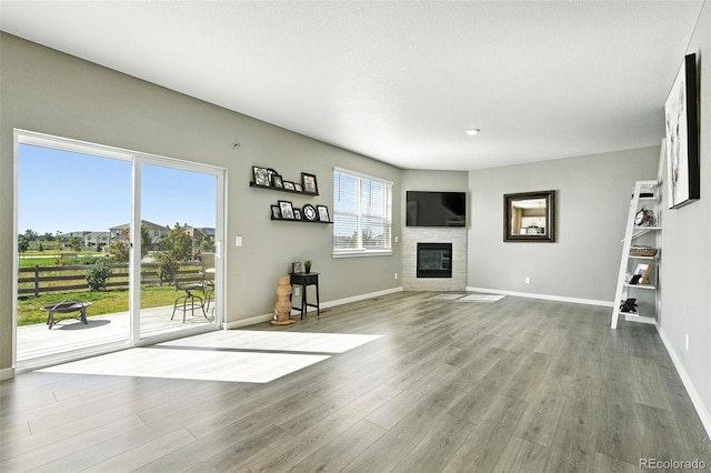 1670 Vantage Pkwy, Berthoud, CO 80513 - unfurnished living room featuring wood finished floors and a glass covered fireplace