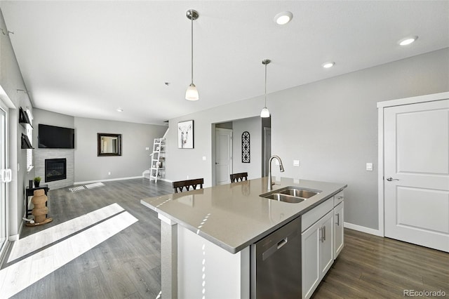 1670 Vantage Pkwy, Berthoud, CO 80513 - kitchen with stainless steel dishwasher, dark wood-style floors, hanging light fixtures, white cabinetry, and a kitchen island with sink