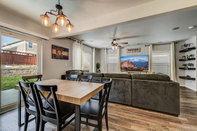 dining area featuring hardwood / wood-style flooring, plenty of natural light, and ceiling fan with notable chandelier