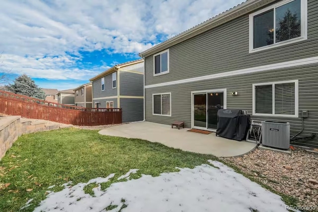 rear view of house with central AC unit, a lawn, and a patio area