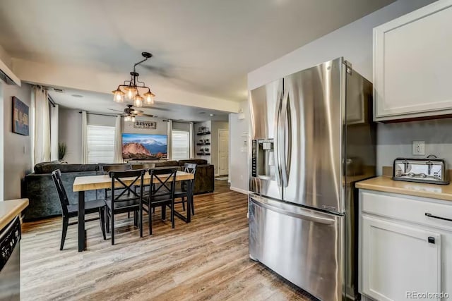 kitchen featuring appliances with stainless steel finishes, decorative light fixtures, light hardwood / wood-style floors, and white cabinets