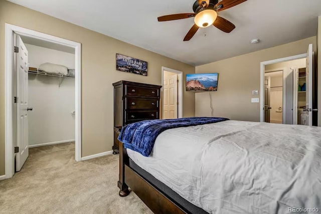 bedroom with a walk in closet, light colored carpet, a closet, and ceiling fan