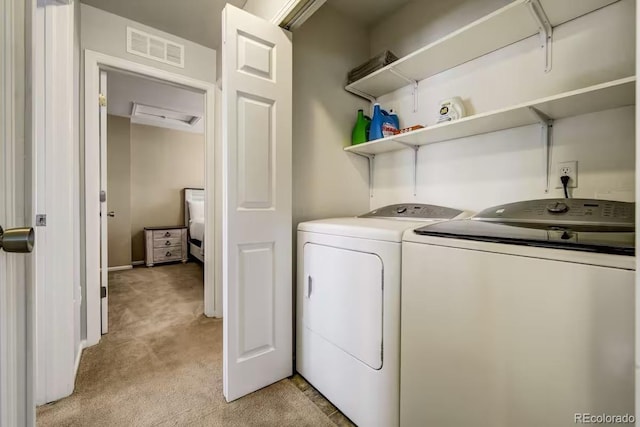 laundry area featuring washing machine and dryer and light colored carpet