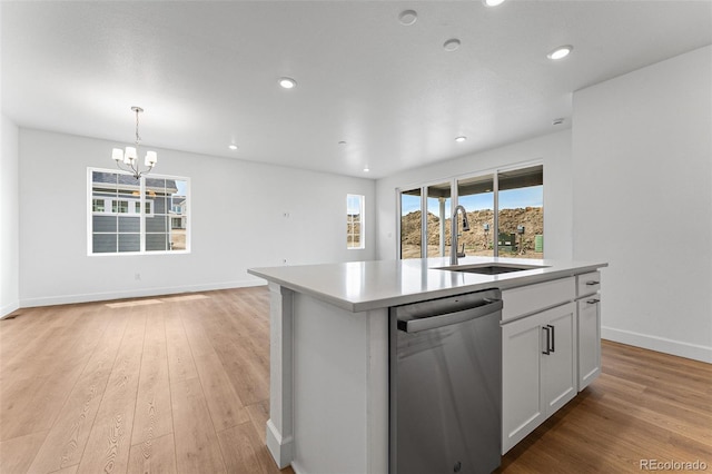 kitchen with white cabinetry, a kitchen island with sink, dishwasher, pendant lighting, and sink