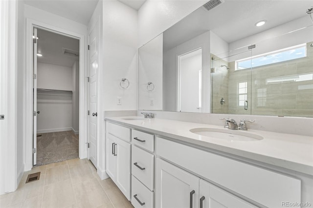 bathroom with a shower with shower door and vanity