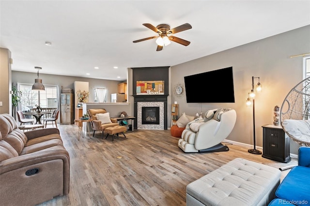 997 Burning Bush Pt, Monument, CO 80132 - living room with light wood finished floors, a ceiling fan, baseboards, a glass covered fireplace, and recessed lighting