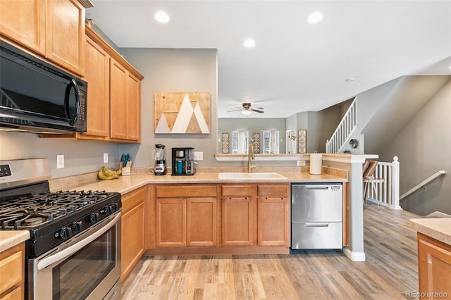 997 Burning Bush Pt, Monument, CO 80132 - kitchen featuring appliances with stainless steel finishes, a sink, a peninsula, a ceiling fan, and light countertops