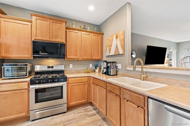 997 Burning Bush Pt, Monument, CO 80132 - kitchen with stainless steel appliances, a sink, light countertops, light wood finished floors, and recessed lighting