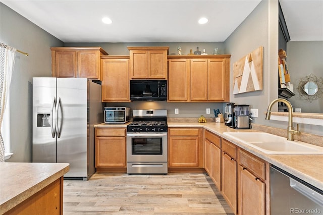997 Burning Bush Pt, Monument, CO 80132 - kitchen featuring stainless steel appliances, a sink, light countertops, light wood-type flooring, and recessed lighting