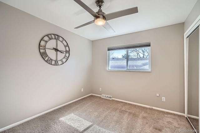 unfurnished bedroom featuring ceiling fan, a closet, visible vents, carpet flooring, and baseboards