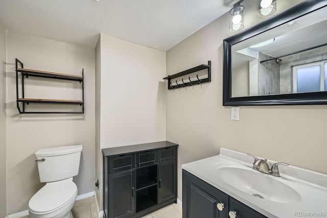 bathroom featuring tile patterned flooring, vanity, baseboards, and toilet