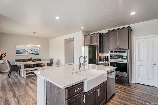 4532 Dewey Ln, Brighton, CO 80603 - kitchen with a sink, appliances with stainless steel finishes, dark wood-style floors, light countertops, and dark brown cabinetry