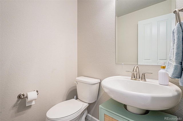 4532 Dewey Ln, Brighton, CO 80603 - bathroom with toilet, a sink, a textured wall, and baseboards