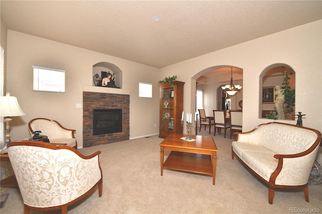 living room featuring arched walkways, carpet, plenty of natural light, and a stone fireplace