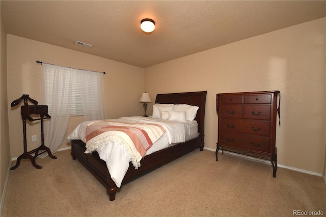 bedroom featuring light carpet, visible vents, and baseboards