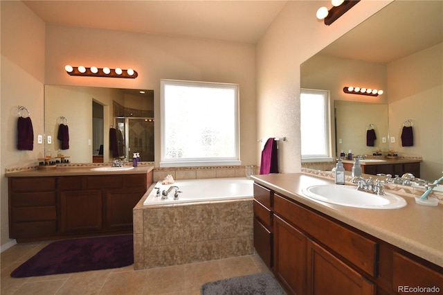 full bathroom with a shower stall, a bath, two vanities, and a sink