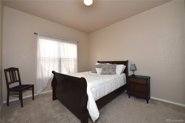 bedroom with light carpet and baseboards