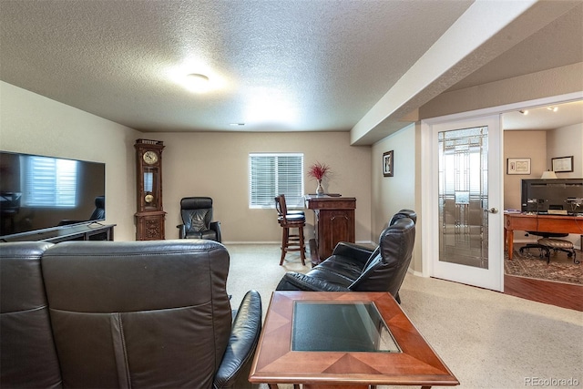 carpeted living room featuring a textured ceiling and baseboards