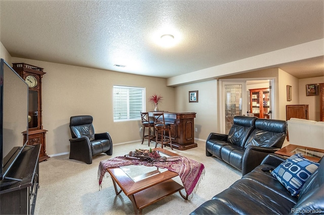 living room with a textured ceiling, baseboards, light carpet, and visible vents