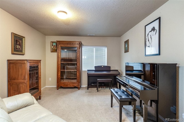 living area with a textured ceiling, baseboards, light carpet, and visible vents