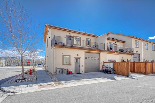 121 Halleys Ave Unit D, Poncha Springs, CO 81242 - view of front of home with stucco siding, an attached garage, fence, and a balcony