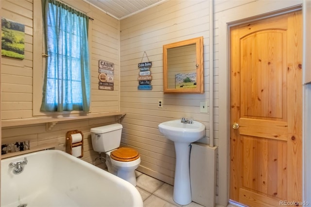 1348 Gcr 64, Grand Lake, CO 80447 - bathroom featuring wooden walls, a freestanding tub, toilet, tile patterned flooring, and a sink