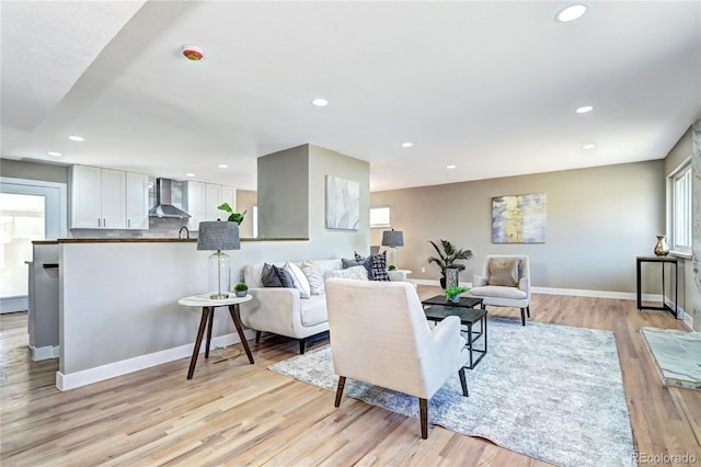 living room with light wood finished floors, recessed lighting, and baseboards