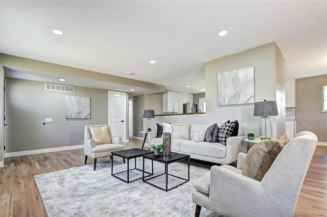 living room with visible vents, recessed lighting, baseboards, and light wood-style floors