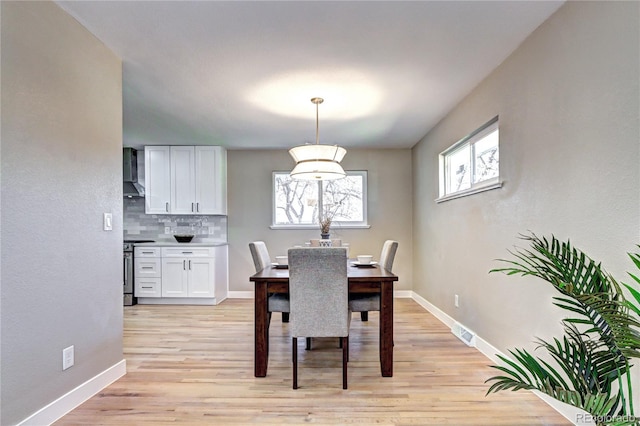 dining area featuring visible vents, light wood-type flooring, and baseboards