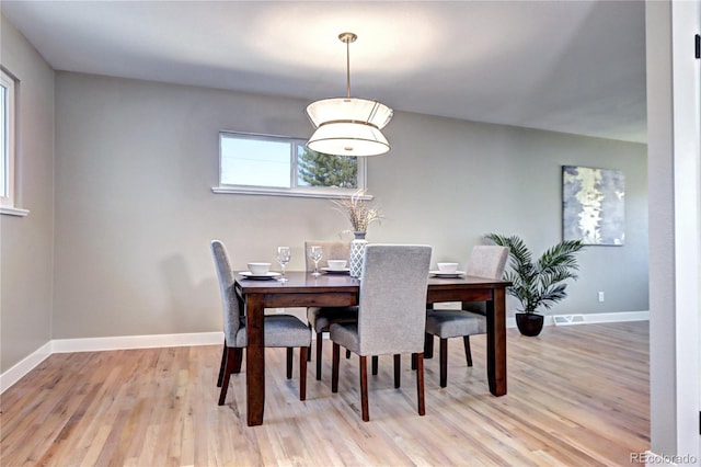 dining space featuring light wood-style flooring and baseboards