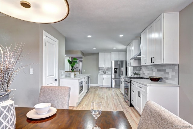 kitchen with a sink, white cabinetry, and stainless steel appliances