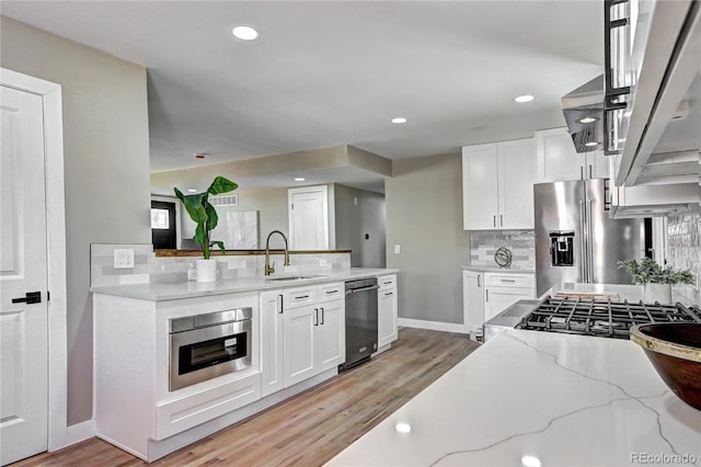 kitchen featuring a sink, light stone counters, white cabinets, and stainless steel fridge with ice dispenser