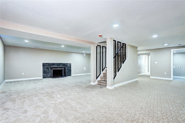 finished below grade area with a premium fireplace, baseboards, carpet, and stairs