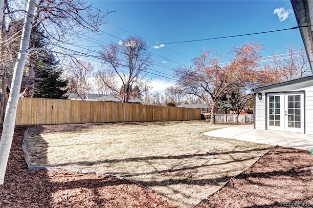 view of yard featuring french doors, a patio, and a fenced backyard