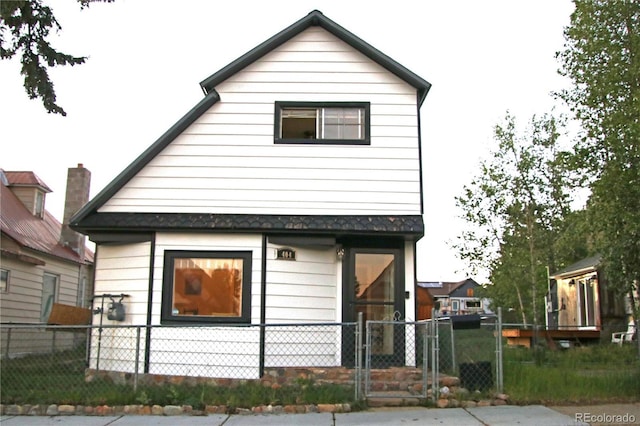 view of side of property with a fenced front yard and a gate